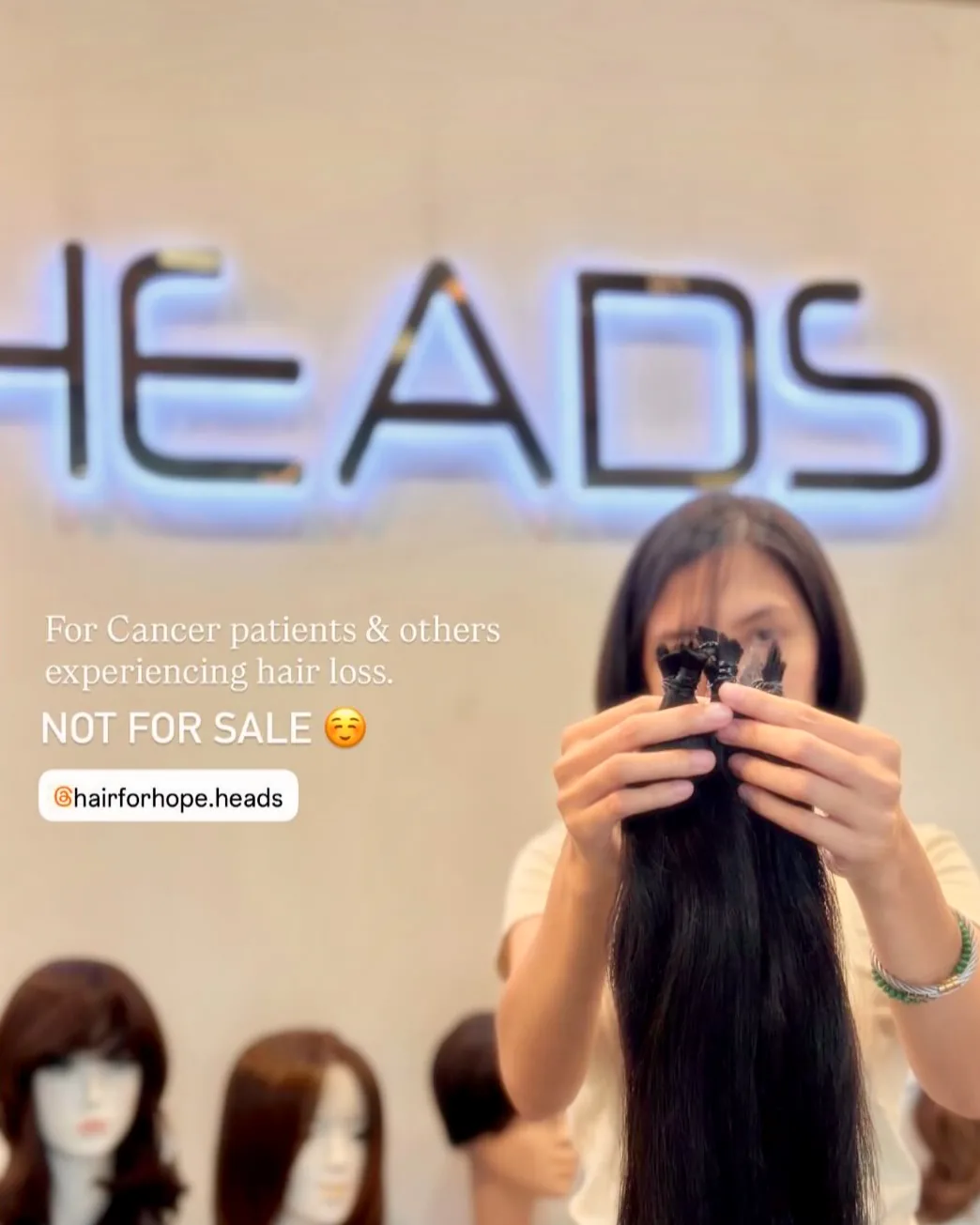 A donor at the HEADS studio holding her cut hair for Hair for Hope — for cancer patients and others experiencing hair loss, not for sale